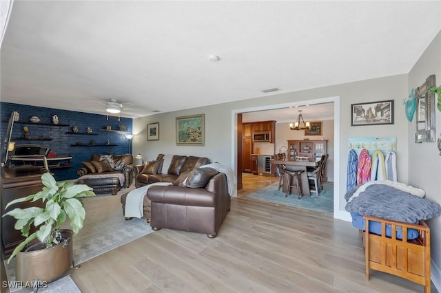 2135 SE 15th St, Cape Coral, FL 33990 - living area with light wood-style floors, a ceiling fan, wine cooler, and a chandelier