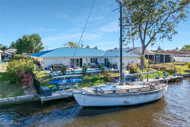 2135 SE 15th St, Cape Coral, FL 33990 - back of property with a water view, a metal roof, and an outdoor pool