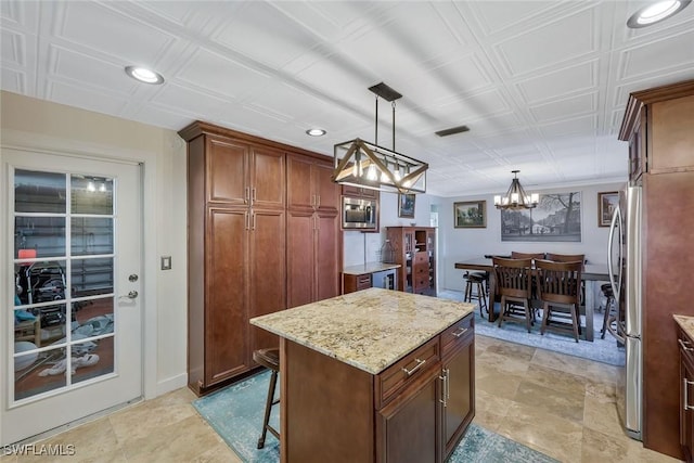 2135 SE 15th St, Cape Coral, FL 33990 - kitchen with a chandelier, light stone countertops, a kitchen island, pendant lighting, and stainless steel appliances