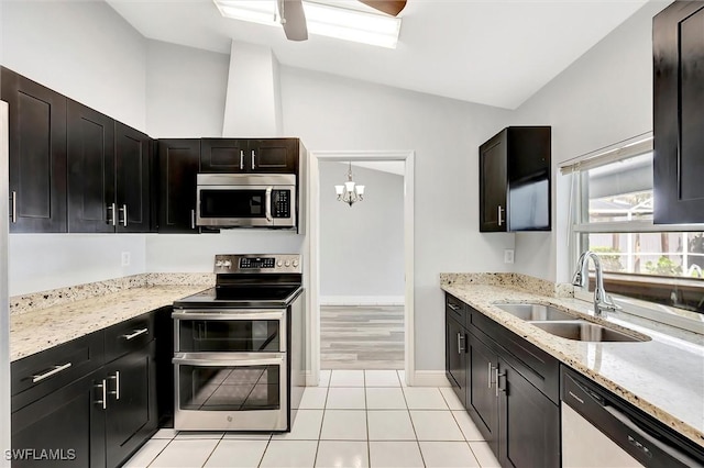 27375 Imperial Oaks Cir, Bonita Springs, FL 34135 - kitchen with light stone counters, lofted ceiling, stainless steel appliances, ceiling fan with notable chandelier, and a sink