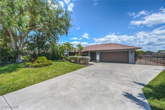 27375 Imperial Oaks Cir, Bonita Springs, FL 34135 - ranch-style house with stucco siding, fence, a front lawn, an attached garage, and driveway