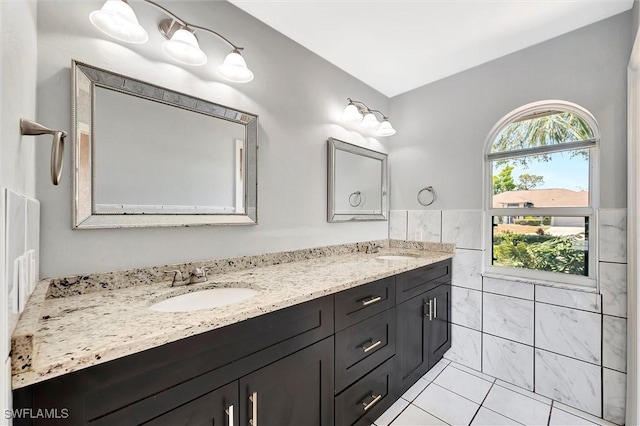 27375 Imperial Oaks Cir, Bonita Springs, FL 34135 - bathroom featuring double vanity, a sink, a wainscoted wall, and tile walls