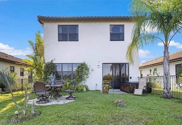 5448 Agostino Way, Ave Maria, FL 34142 - rear view of house with a hot tub, stucco siding, a fenced backyard, a patio area, and a lawn