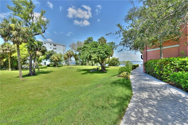 view of home's community featuring a water view and a lawn