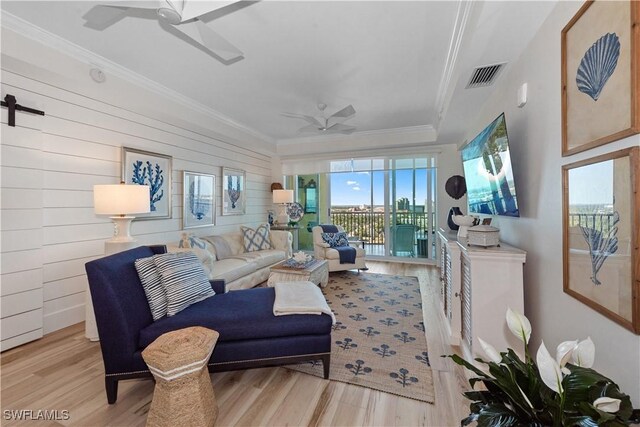 living area featuring ornamental molding, visible vents, wood finished floors, and ceiling fan