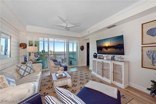 living area featuring ornamental molding, a ceiling fan, visible vents, and wood finished floors