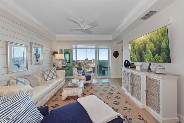 living room with ornamental molding, visible vents, and wood finished floors