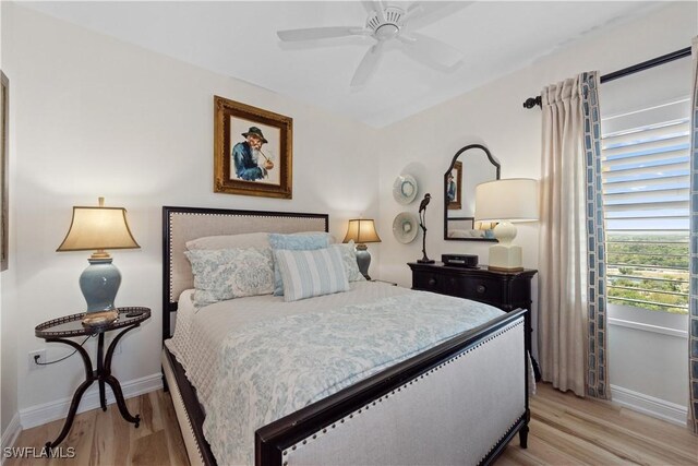 bedroom featuring baseboards, light wood-style floors, and a ceiling fan