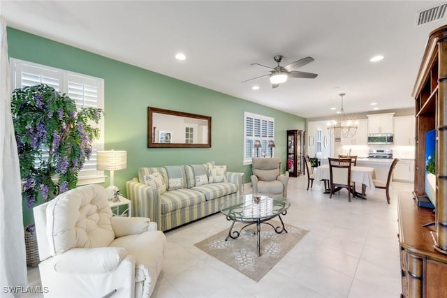 living room featuring ceiling fan with notable chandelier, visible vents, and recessed lighting