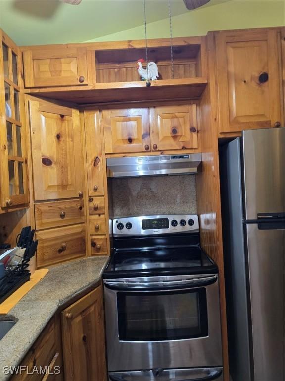1017 NW 15th St, Cape Coral, FL 33993 - kitchen with glass insert cabinets, brown cabinetry, stainless steel appliances, and under cabinet range hood