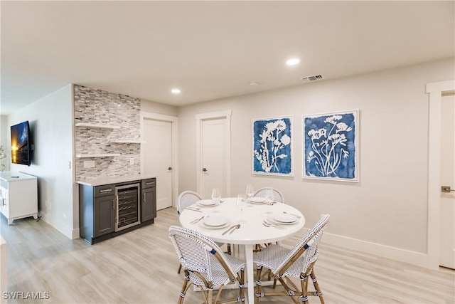 668 104th Ave N, Naples, FL 34108 - dining room featuring visible vents, a dry bar, baseboards, light wood finished floors, and beverage cooler