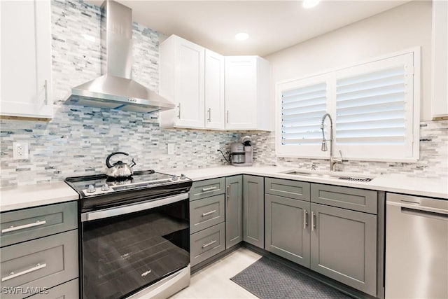668 104th Ave N, Naples, FL 34108 - kitchen with backsplash, appliances with stainless steel finishes, a sink, light countertops, and wall chimney exhaust hood