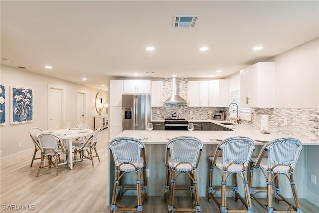 668 104th Ave N, Naples, FL 34108 - kitchen with visible vents, stainless steel fridge with ice dispenser, wall chimney exhaust hood, tasteful backsplash, and a sink
