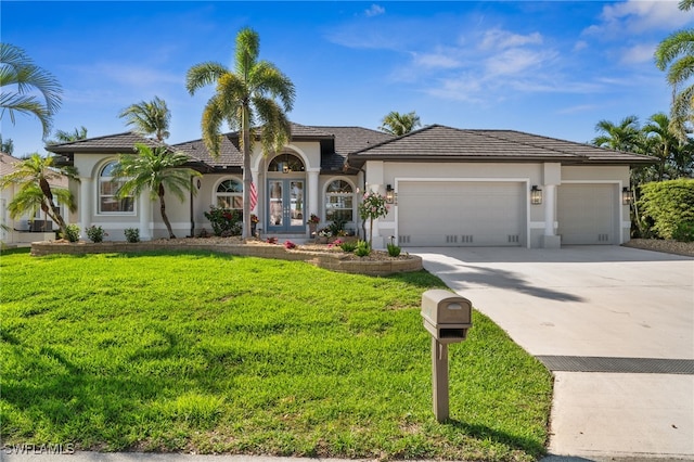 mediterranean / spanish home featuring an attached garage, concrete driveway, stucco siding, and a front yard