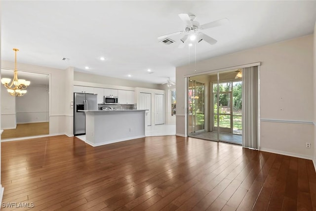 20657 Country Barn Dr, Estero, FL 33928 - unfurnished living room with visible vents, ceiling fan with notable chandelier, baseboards, and wood finished floors