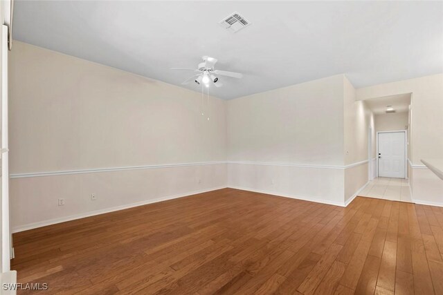 20657 Country Barn Dr, Estero, FL 33928 - empty room featuring visible vents, ceiling fan, hardwood / wood-style flooring, and baseboards