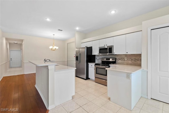 20657 Country Barn Dr, Estero, FL 33928 - kitchen with white cabinets, a sink, light countertops, appliances with stainless steel finishes, and backsplash