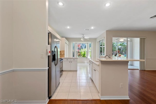 20657 Country Barn Dr, Estero, FL 33928 - kitchen with stainless steel fridge, light countertops, a ceiling fan, white cabinetry, and visible vents