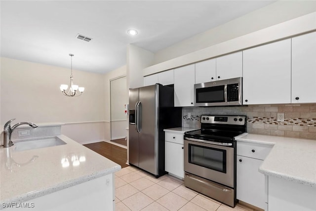 20657 Country Barn Dr, Estero, FL 33928 - kitchen with tasteful backsplash, white cabinets, visible vents, stainless steel appliances, and a sink