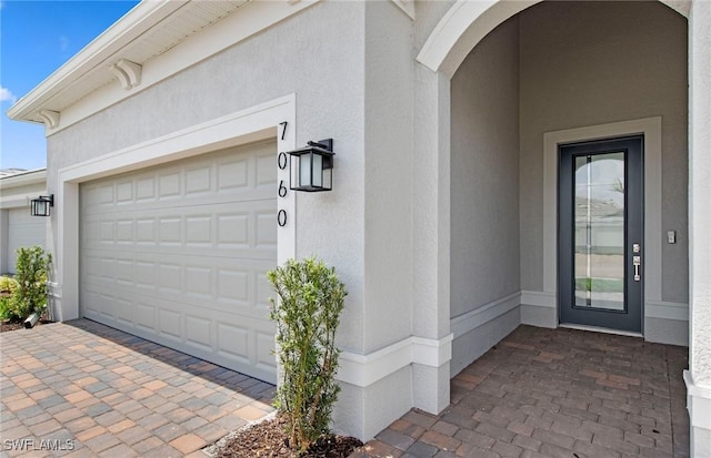 7060 Del Webb Oak Creek Blvd, North Fort Myers, FL 33917 - doorway to property with stucco siding, driveway, and a garage
