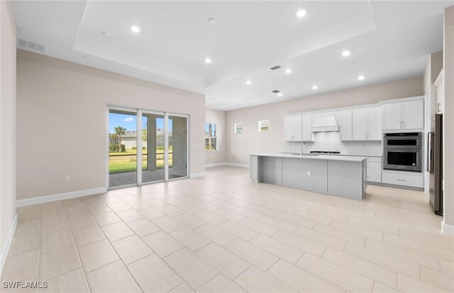 7060 Del Webb Oak Creek Blvd, North Fort Myers, FL 33917 - kitchen with a raised ceiling, open floor plan, stainless steel double oven, fridge, and a sink