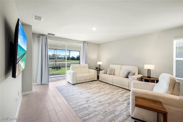living room featuring baseboards, wood finished floors, visible vents, and recessed lighting