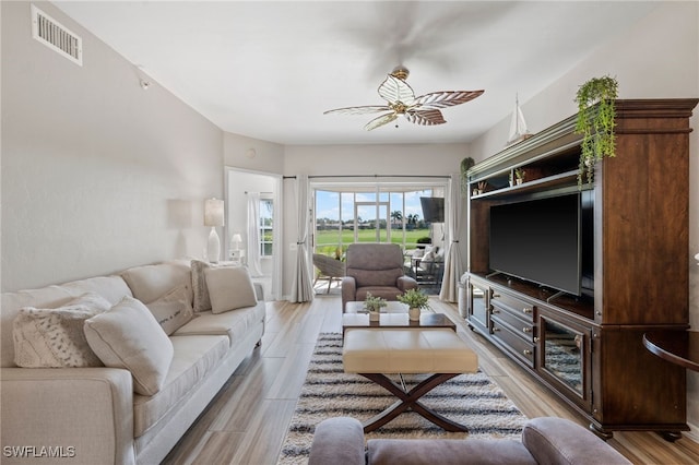 living room featuring visible vents, a ceiling fan, and light wood-style floors