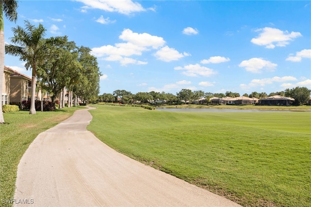 view of property's community with a water view and a yard