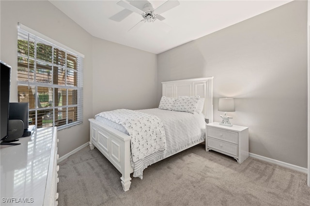 bedroom featuring light carpet, multiple windows, and baseboards