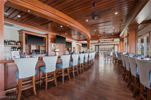 interior space featuring a bar, pendant lighting, wooden ceiling, and dark wood finished floors