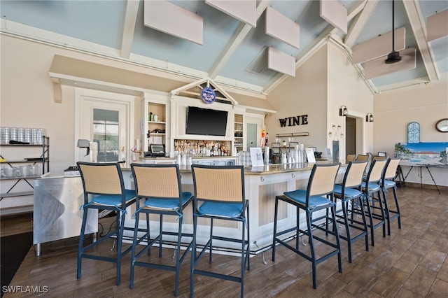kitchen featuring high vaulted ceiling, a breakfast bar, beamed ceiling, and dark wood finished floors