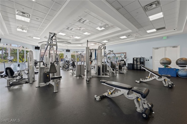 gym featuring a paneled ceiling, visible vents, and a raised ceiling