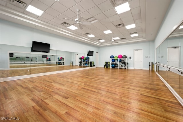 workout area featuring a ceiling fan, wood finished floors, a drop ceiling, and visible vents