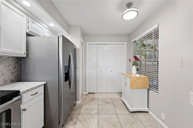 kitchen with white cabinets, tasteful backsplash, light countertops, and appliances with stainless steel finishes