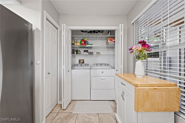 laundry room with washer and dryer, light tile patterned floors, and laundry area
