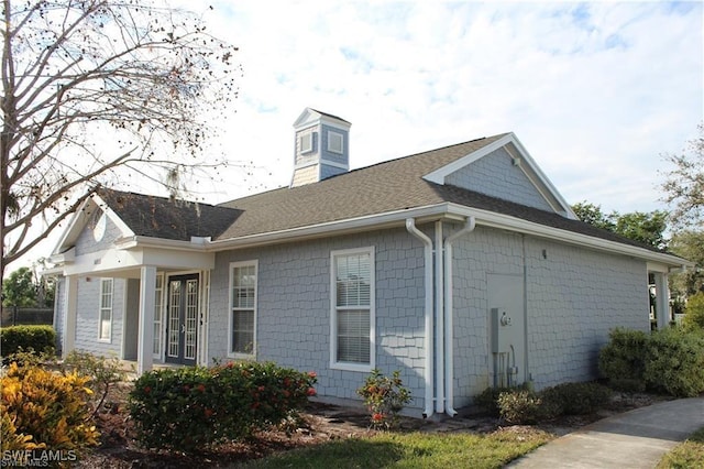 14870 Pleasant Bay Ln Unit 1208, Naples, FL 34119 - view of home's exterior featuring a chimney and a shingled roof