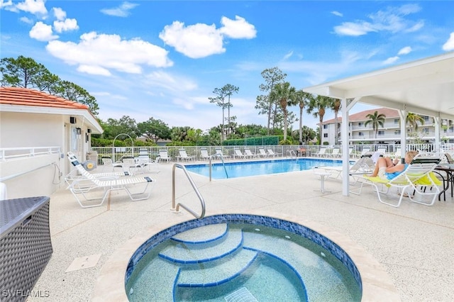 pool featuring a patio, a community hot tub, and fence