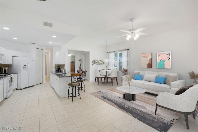 living room with a ceiling fan, visible vents, light tile patterned floors, and recessed lighting