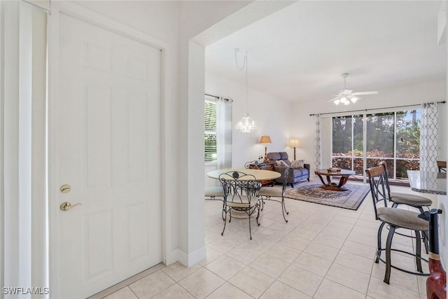 dining area with light tile patterned flooring, ceiling fan, and baseboards