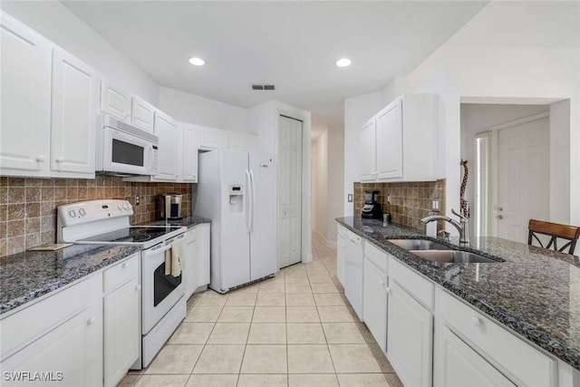 kitchen with a sink, white appliances, white cabinetry, decorative backsplash, and visible vents