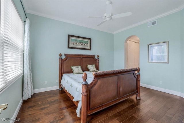 bedroom with crown molding, arched walkways, dark wood-style floors, and visible vents