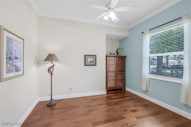 empty room featuring baseboards, ornamental molding, a ceiling fan, and wood finished floors