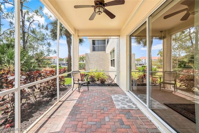 unfurnished sunroom featuring a ceiling fan