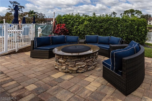 view of patio / terrace with an outdoor living space with a fire pit and fence
