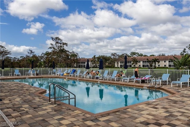 community pool featuring fence and a patio area