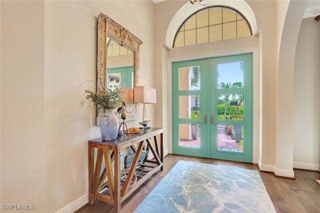 foyer with french doors, baseboards, and wood finished floors