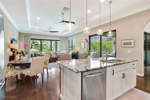 kitchen featuring a tray ceiling, a sink, visible vents, ceiling fan, and dishwasher