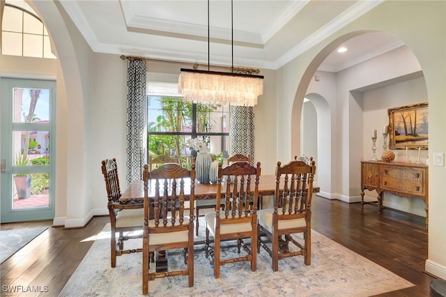 dining area with a healthy amount of sunlight, hardwood / wood-style flooring, and an inviting chandelier