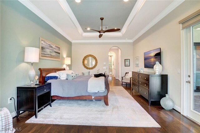 bedroom with arched walkways, a raised ceiling, recessed lighting, dark wood-type flooring, and ornamental molding