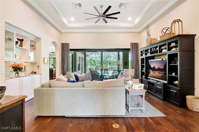 living area with visible vents, a ceiling fan, arched walkways, and a high ceiling